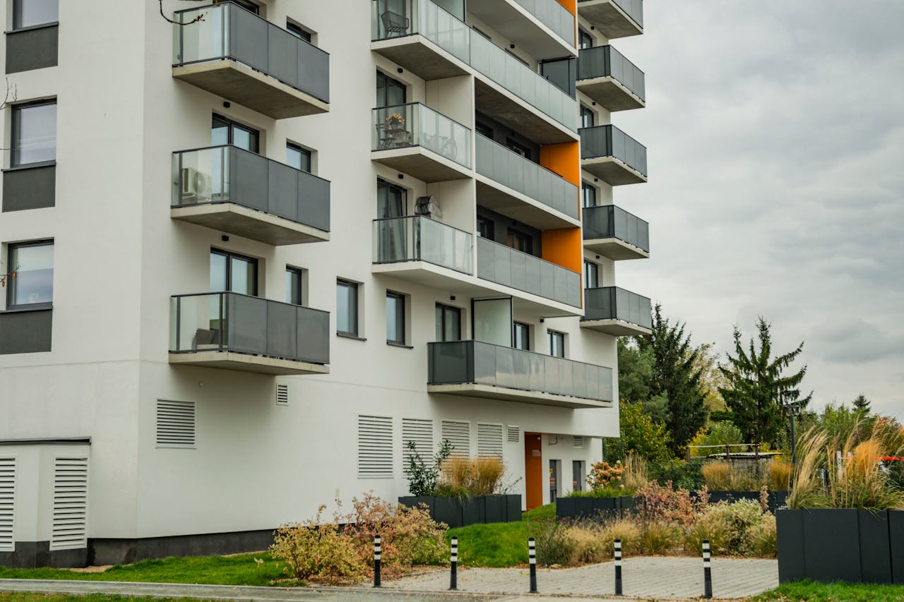 our-experience Contemporary apartment complex featuring glass balconies and landscaped surroundings.