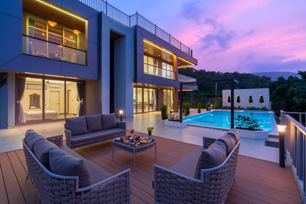 services-02 Stunning modern villa with outdoor seating and pool, captured at sunset.
